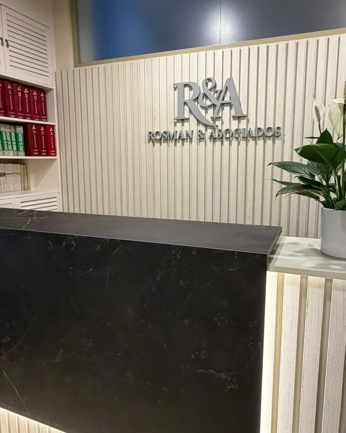 Recepción del Estudio Rosman & Asociados en Santa Fe, con el logo sobre la pared